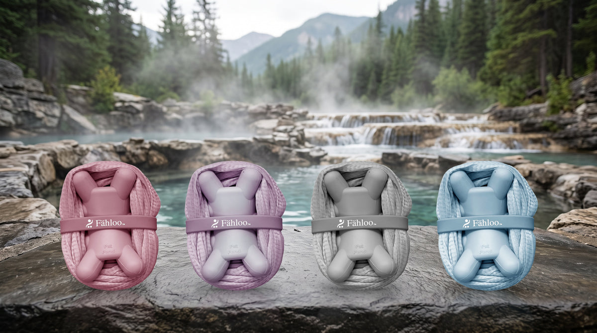 Fähloo in Desert Rose, French Lilac, Pebble Grey and Sea Salt Blue on a rock by a hot spring